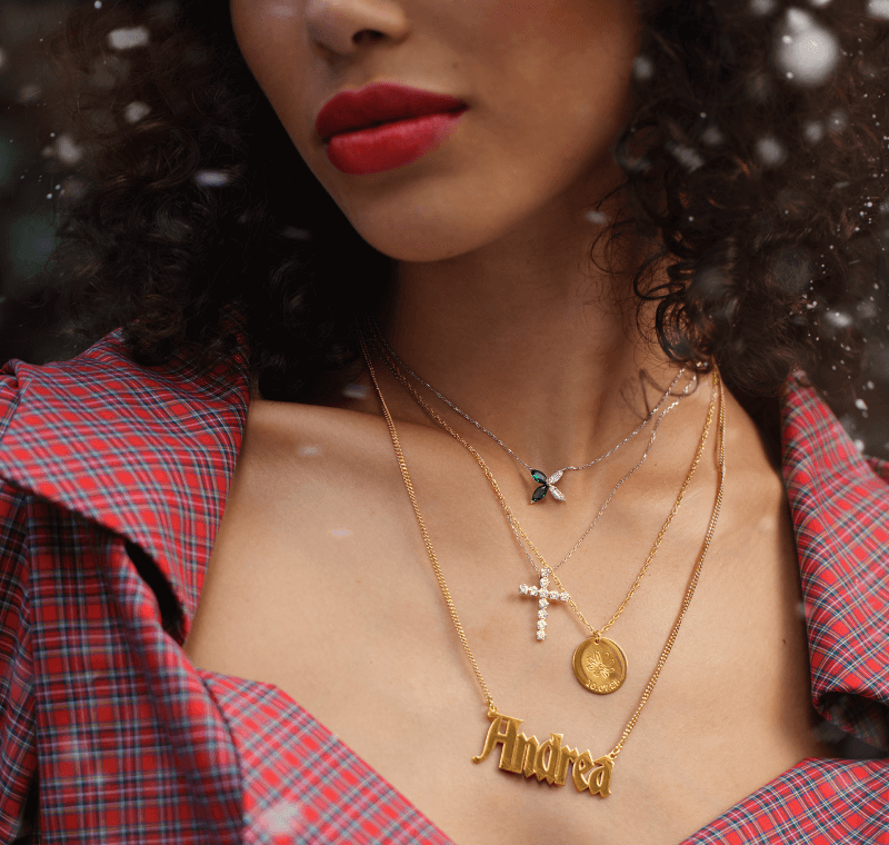 Woman showcasing layered personalized necklaces.