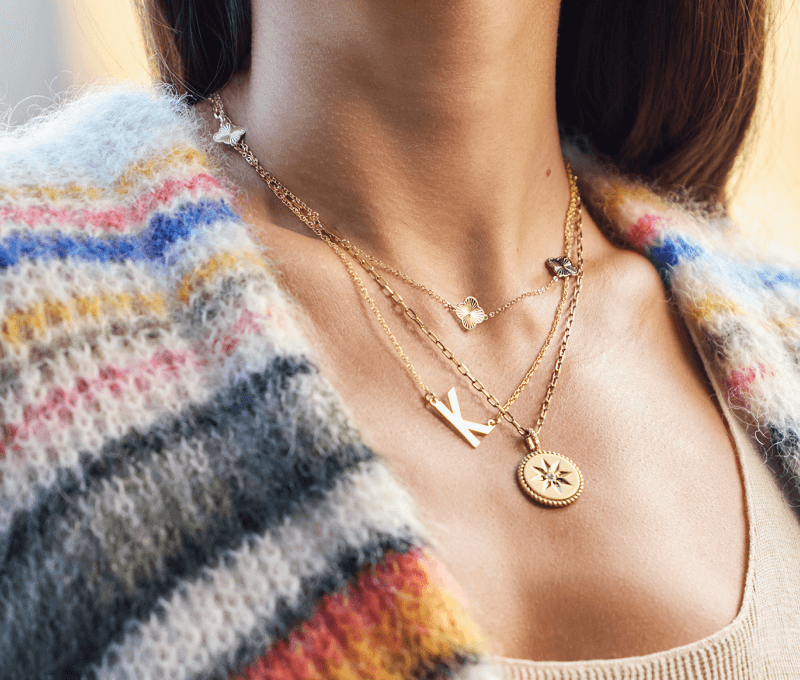 Woman showcasing layers of necklaces.