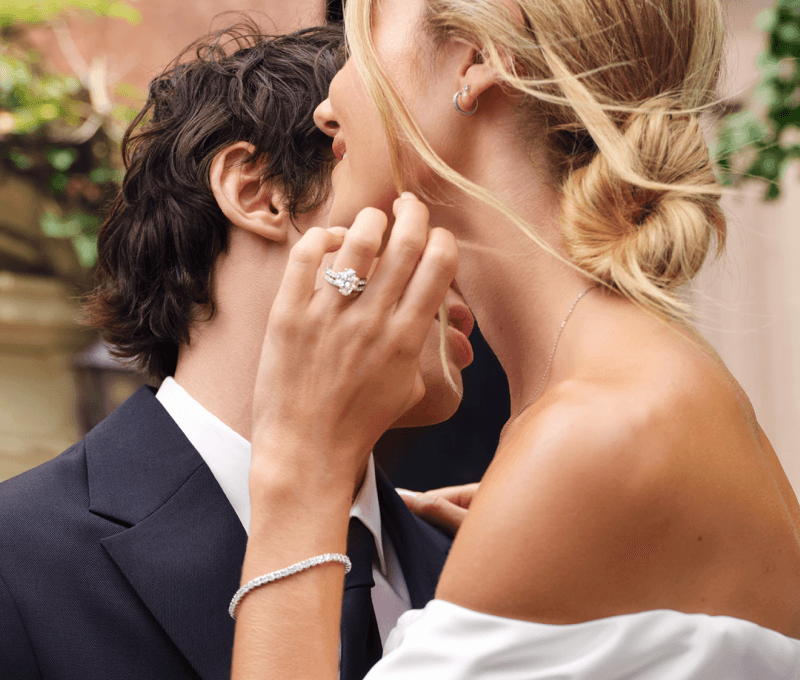 Bride showcasing earrings, ring and bracelet.