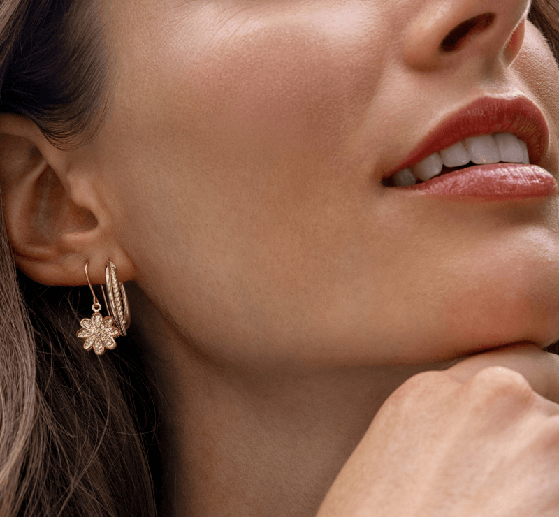 Woman showcasing multiple earrings.