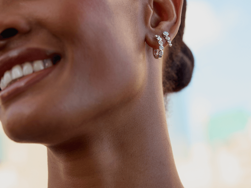A smiling woman displays stunning small hoop earrings