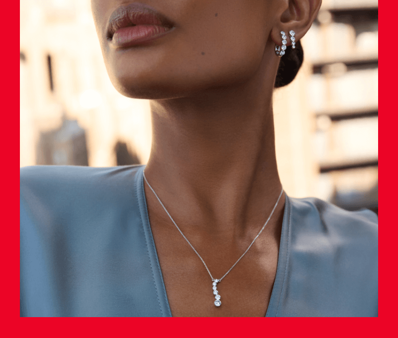 Woan showcasing earrings and necklace.
