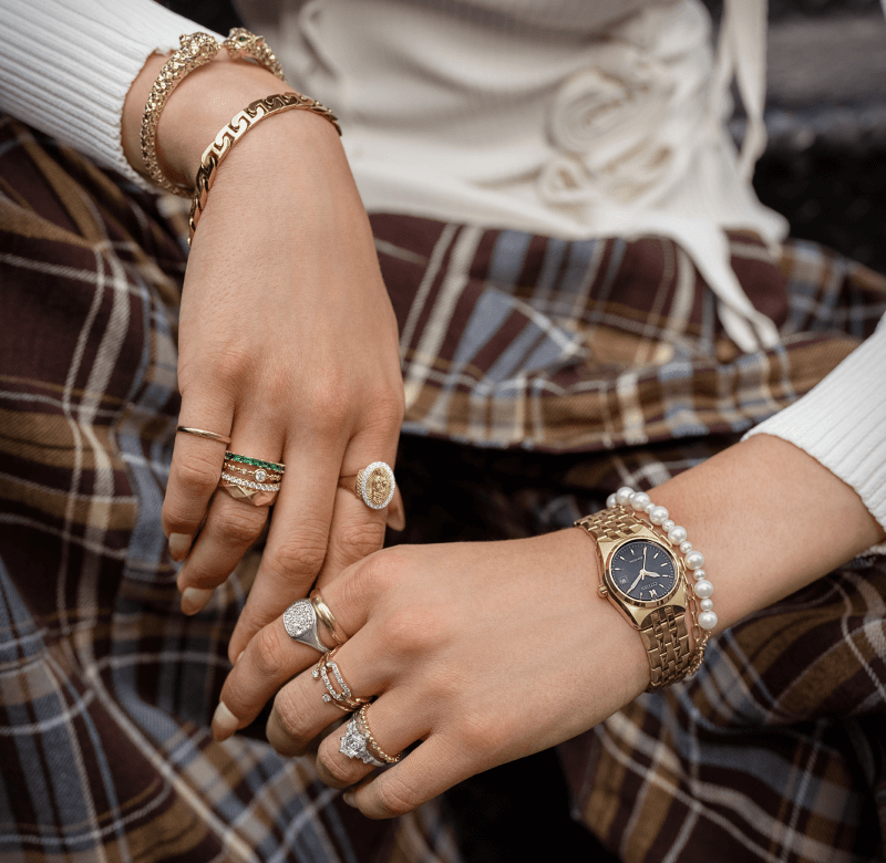 Woman showcasing multiple rings bracelets and watch found in the Black Friday Sale. 