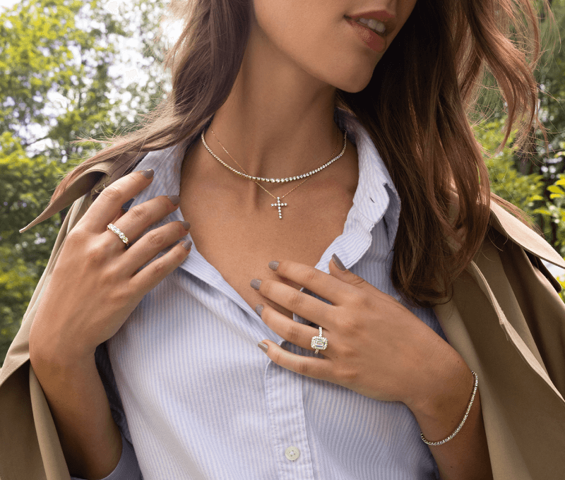 Beautiful woman showcasing elegant bracelet, rings, and necklaces.