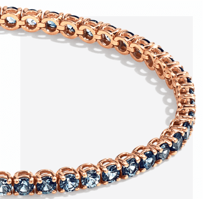 Rose-gold tennis bracelet accented with alternating blue and neutral gemstones.