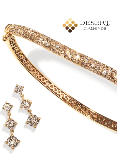 Yellow gold bangle bracelet with pavé diamonds, next to matching geometric diamond drop earrings. Desert Diamond logo.