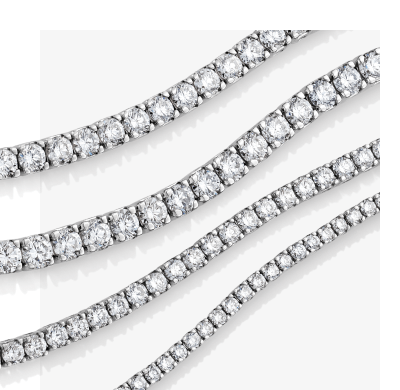 Various white gold diamond tennis necklaces in layered curves.