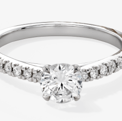 White gold engagement ring with a round diamond solitaire and pavé diamond band.