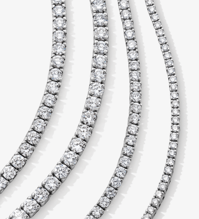 Multiple white gold tennis necklaces set with round diamonds in prong settings.