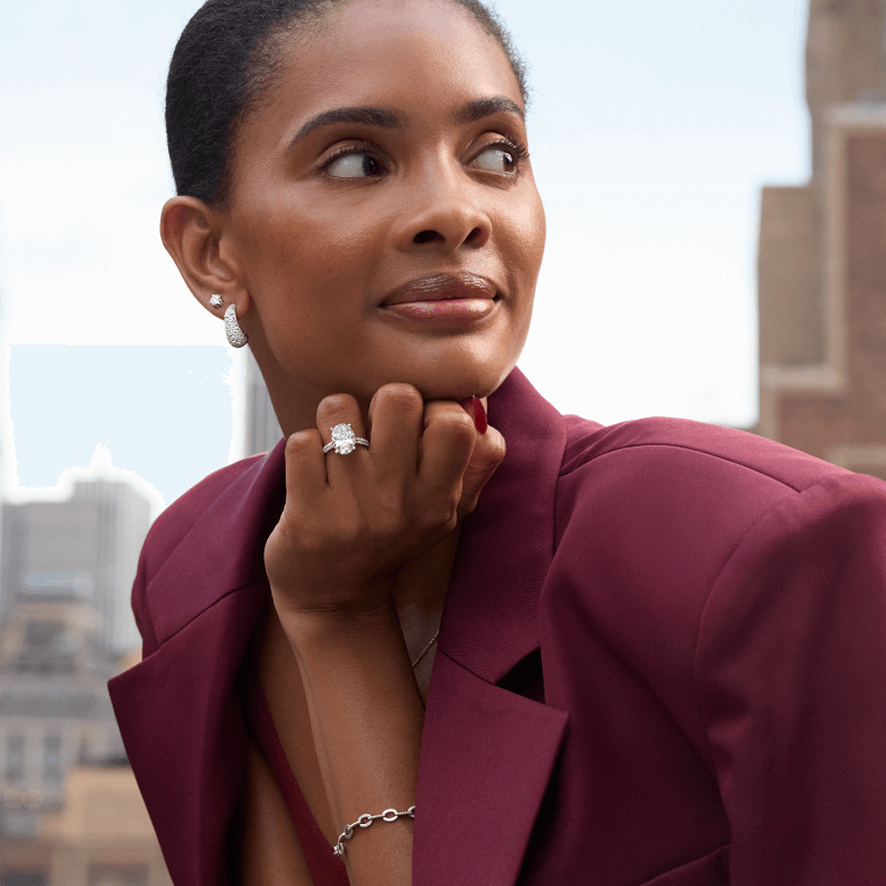 Woman Wearing Diamond Stud Earrings and Hoops, Bracelet and White Gold Oval Engagement Ring.