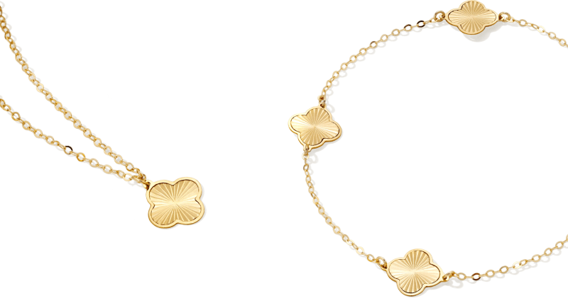 A matching yellow gold and clover decal bracelet and necklace.