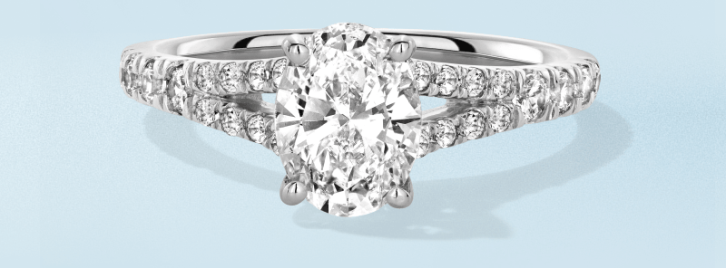 White metal oval diamond engagement ring with double pavé band.