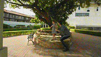 Animated GIF featuring a man and his little daughter near a tree. He is wearing a silver-tone Bulova watch with blue dial.