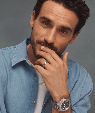 Man wearing a silver watch with silver wedding band. 
