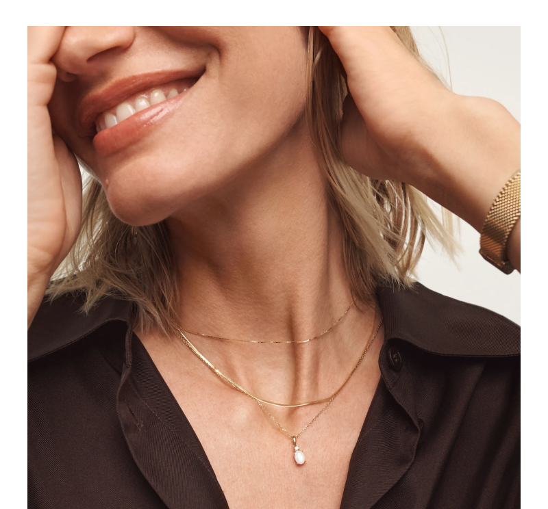 Woman wearing layered gold necklace.