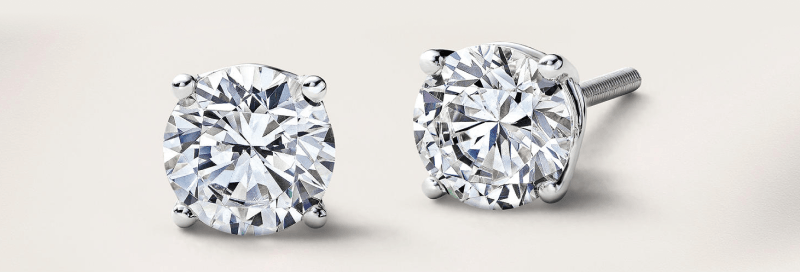 A pair of round cut white metal diamond stud earrings.