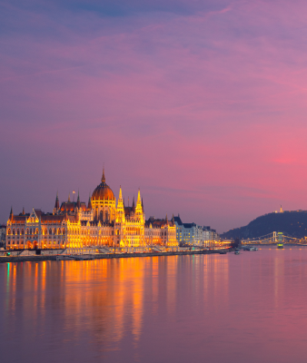 The Hungarian Parliament Building in Budapest lit up at sunset.