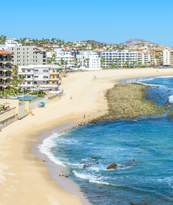 A beautiful beach scene with buildings in the background.