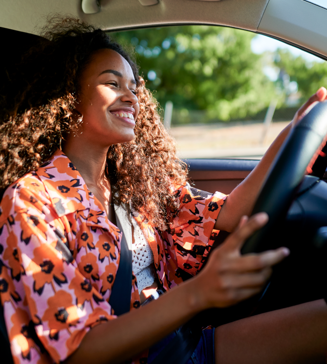Young woman at the wheel enjoying a sunny drive.
