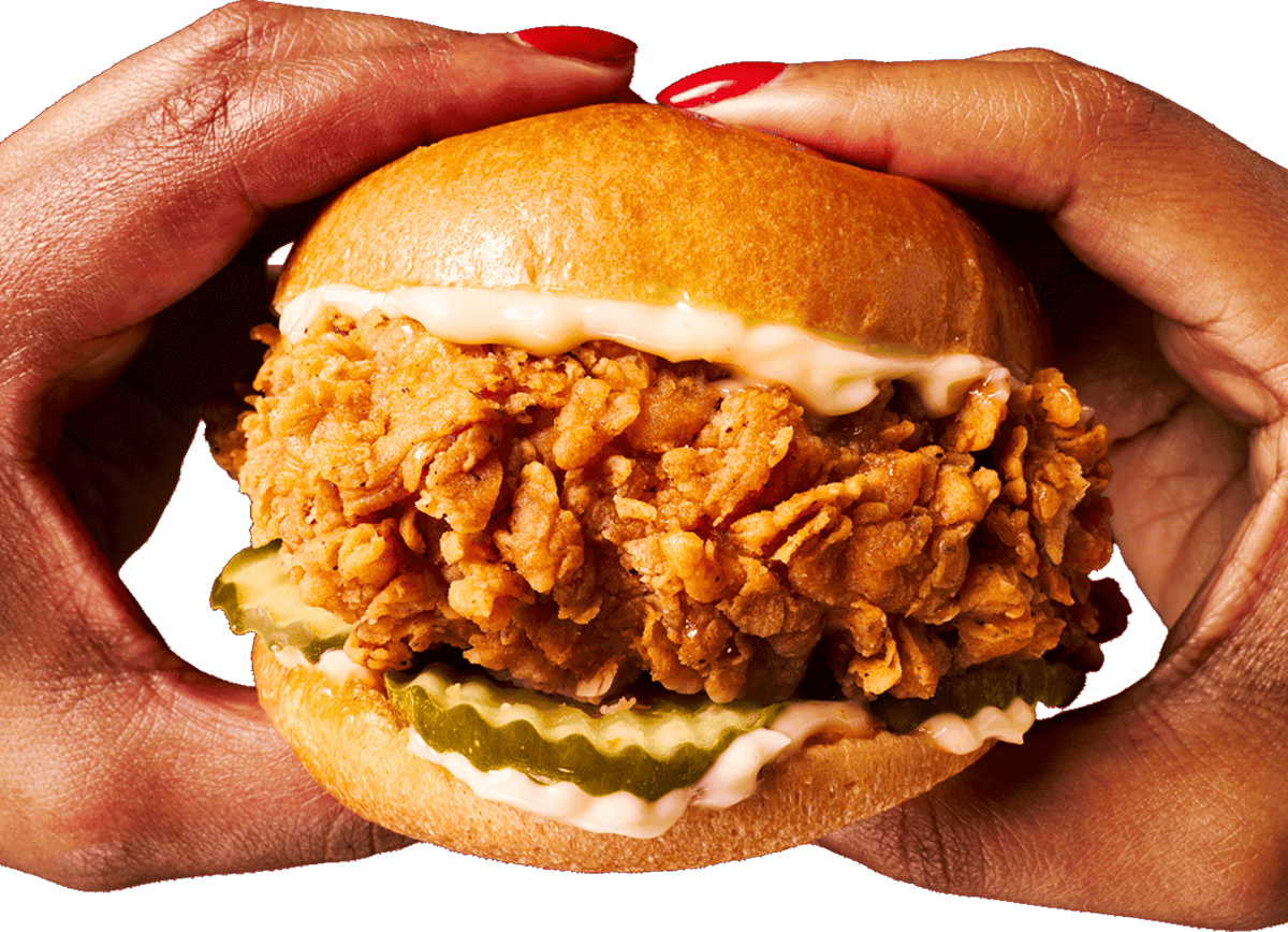 A pair of hands holding a crispy KFC Chicken Sandwich