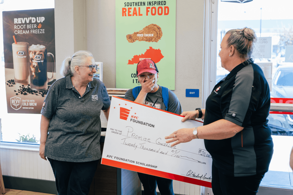A woman is surprised with a giant check for $20,000.