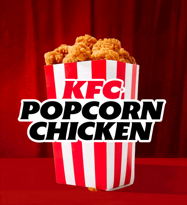 Small fried chicken pieces flying out of a popcorn bucket.