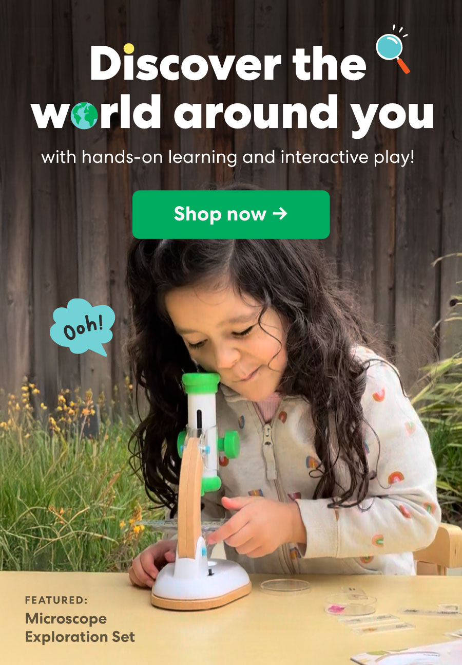 Child using a KiwiCo microscope outdoors, smiling with curiosity. Header text: “Discover the world around you” with subtext about hands-on learning and interactive play. Green CTA button reads “Shop now.”