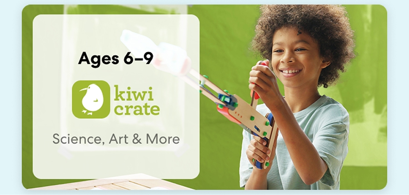Young child smiling while working on a science experiment from KiwiCo Labs. Hands-on STEM learning for ages 6–9