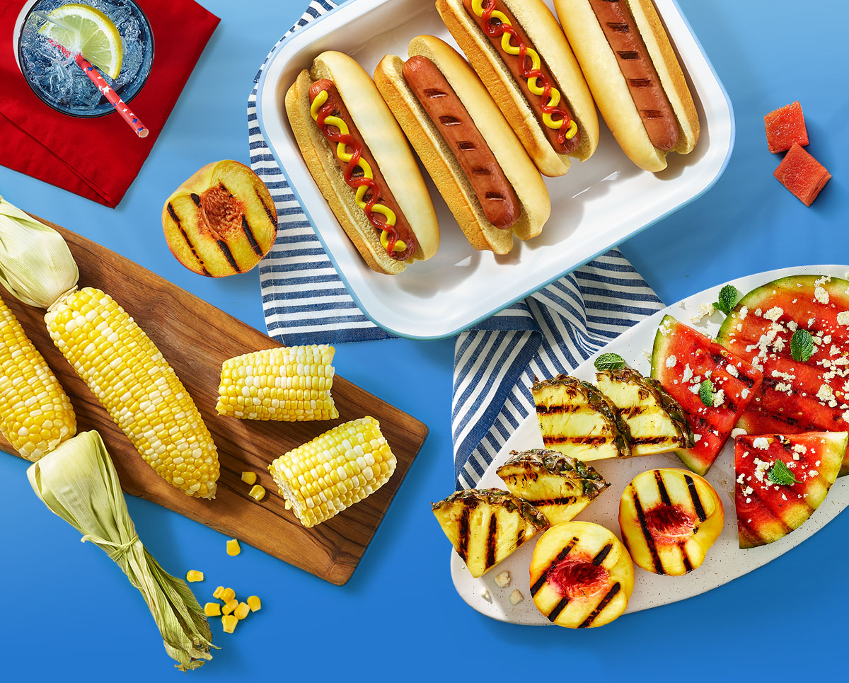 Corn, hot dogs, summer drink, grilled veggies and grilled fruits