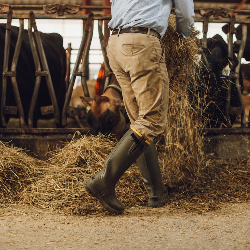 Man wearing Burly Aero in Dark Olive scattering hay