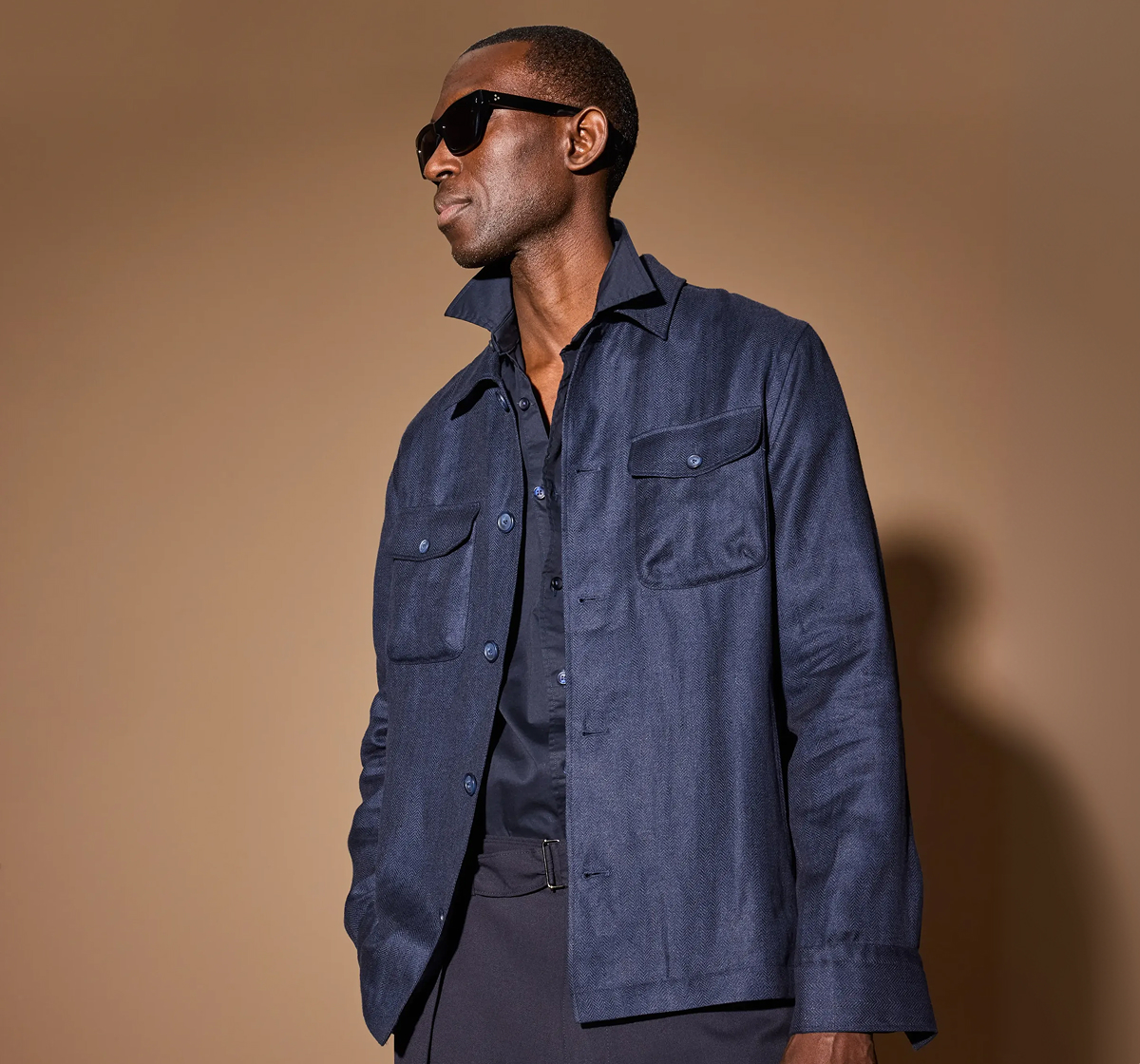 Model Wearing The Eton Linen Four-pocket Overshirt, Paired With A Blue Button-up And Blue Pants. Click Here To Shop The Best Of Our Favorite Makers.