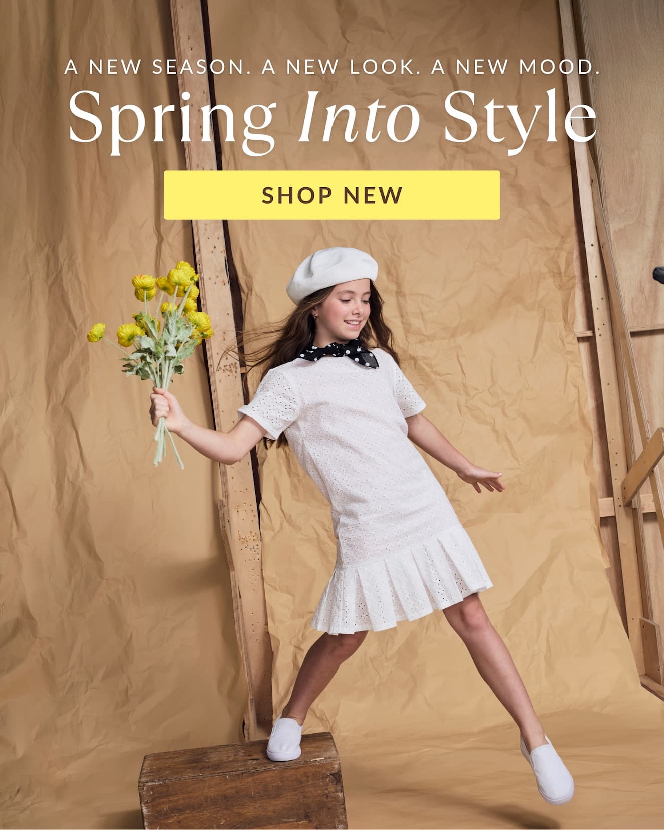 Girl wearing white eyelet dress holding yellow flowers; white words spring into style shop new