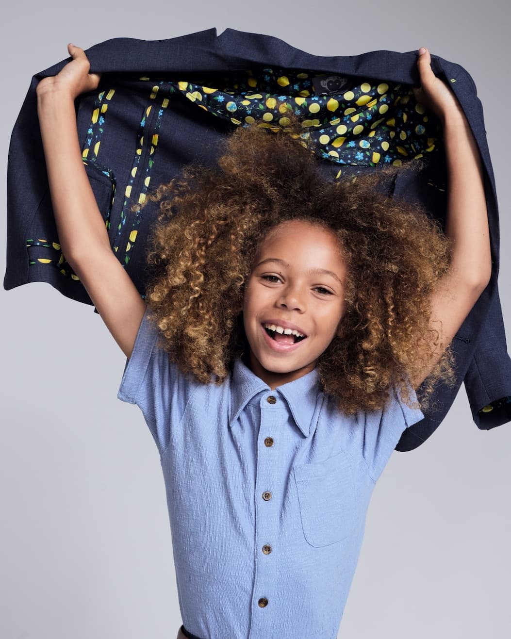 Boy holding suit with lemon lining