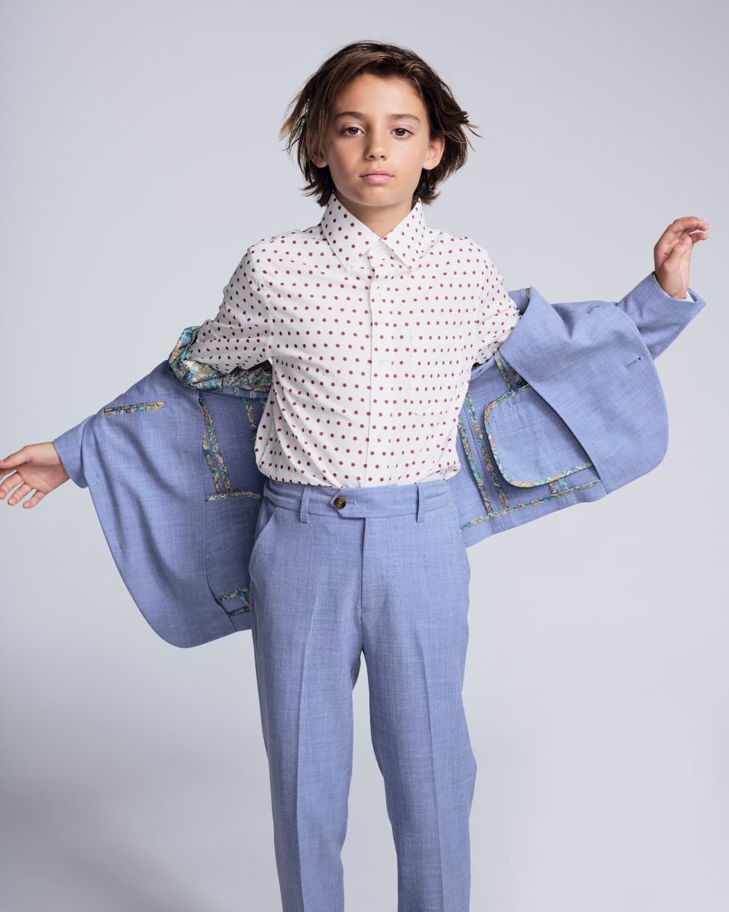 Boy holding suit with spring sage lining