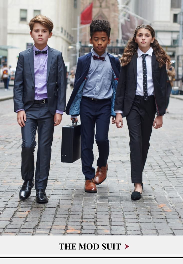 Two boys and a girl dressed in suits on wall street