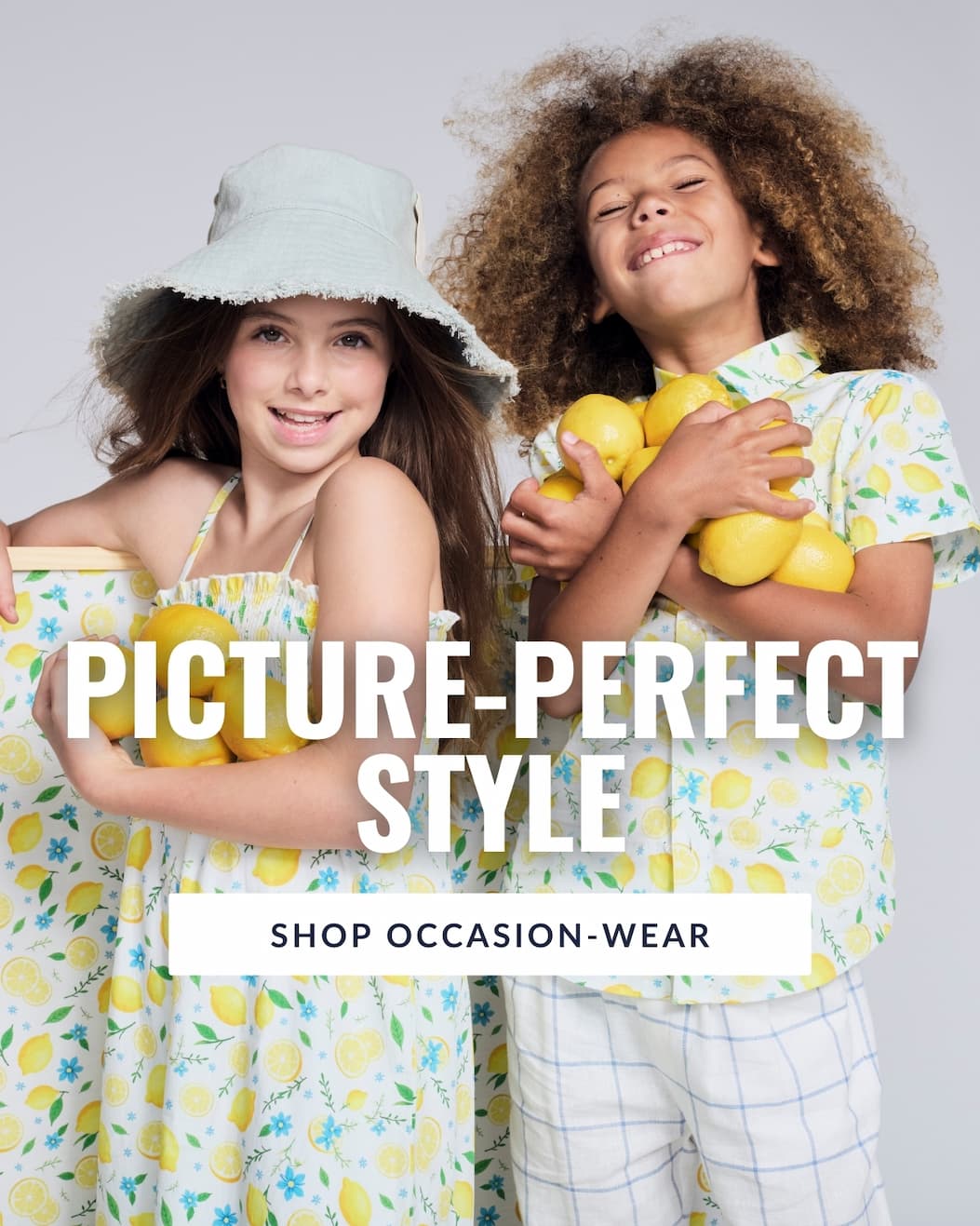 Kids on a grey background in lemon print clothes holding lemons with white text picture-perfect style and button shop occasion-wear