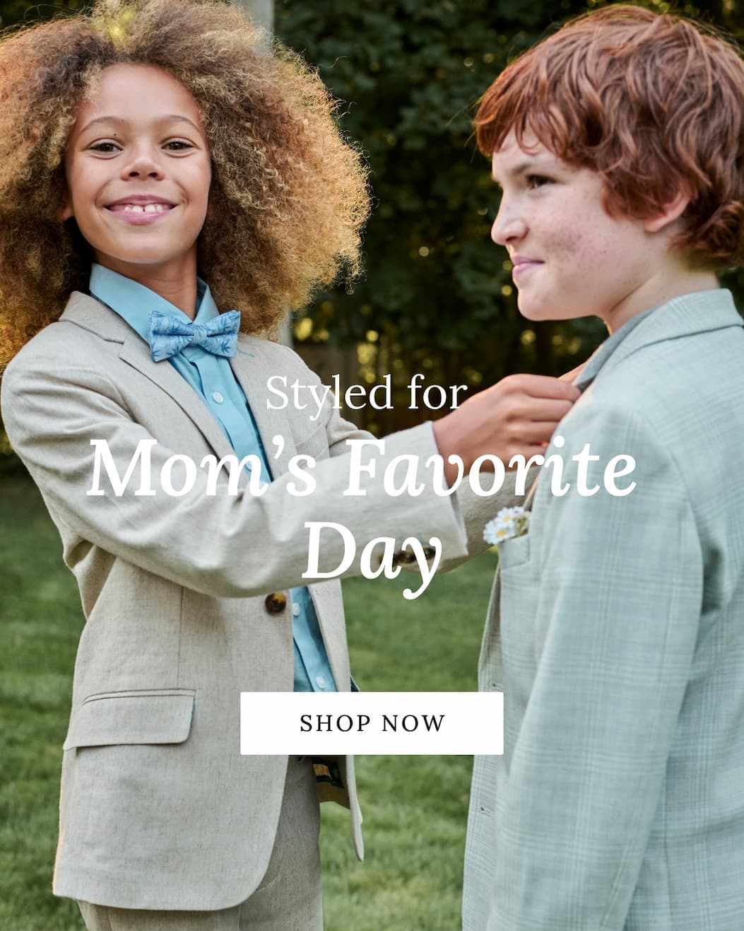 two boys wearing suits smiling outside