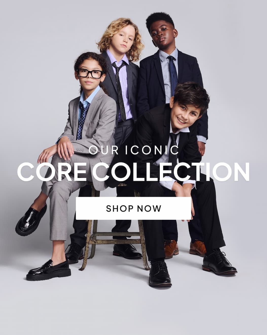 Group of kids wearing suits on grey background with text our iconic core collection and white shop now button