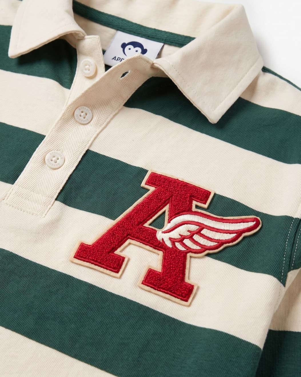 Close up of green and white striped polo with A letter on right side