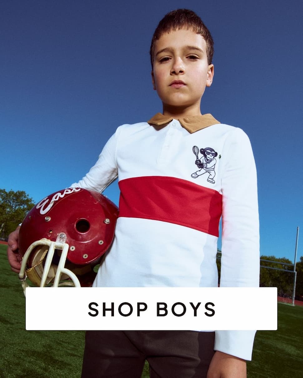 Boy wearing red and white polo holding football helmet with text shop boys