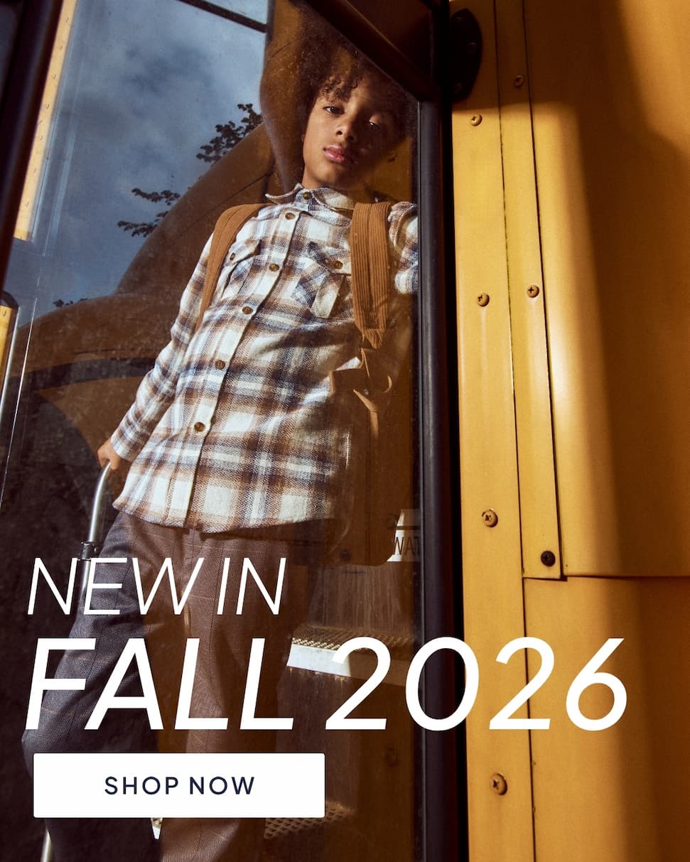 Boy wearing white flannel on school bus with text new in fall 2026 with shop now button