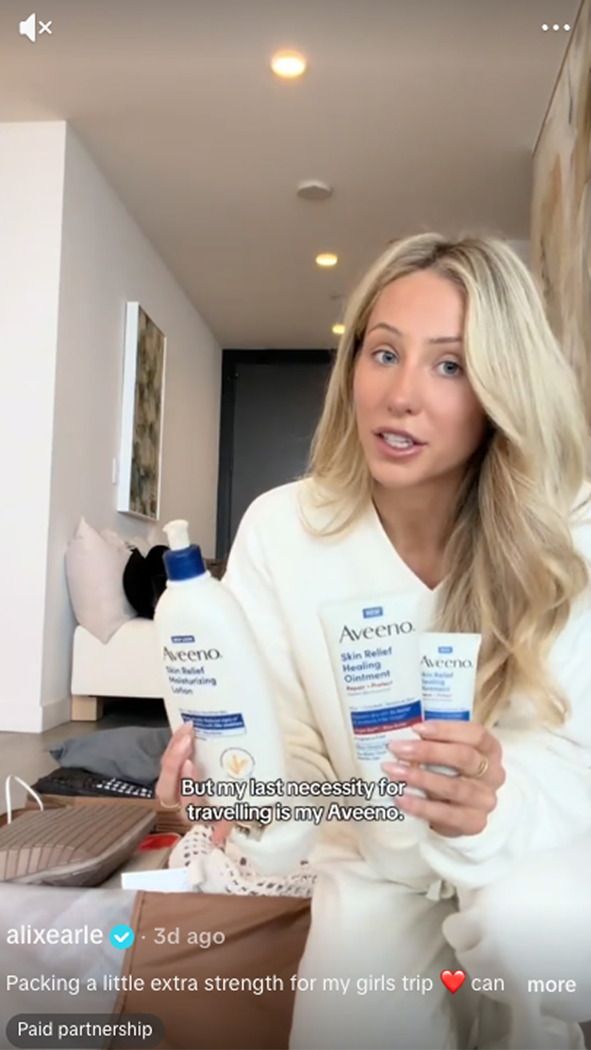 Woman holding Aveeno® Skin Relief Moisturizing Lotion and two sizes of the NEW Aveeno® Skin Relief Healing Ointment as she is packing for a trip.