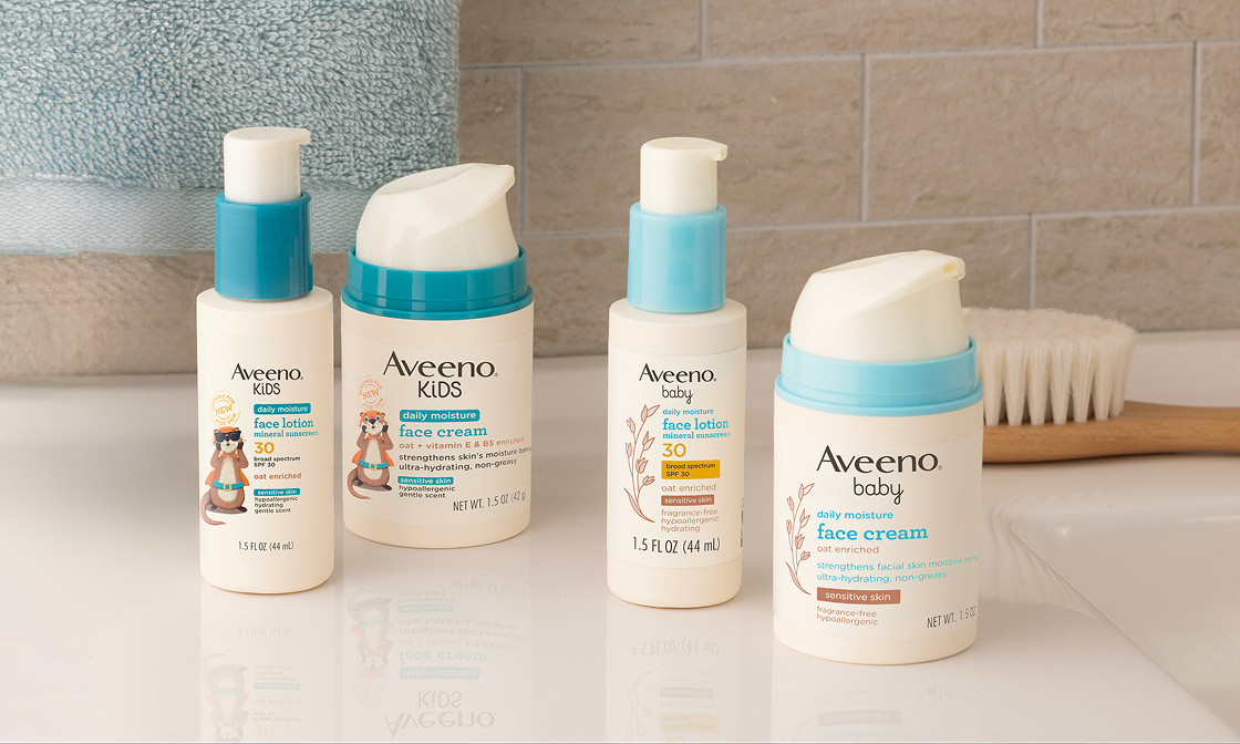 Aveeno® Kids Daily Moisture Face Lotion & Mineral Sunscreen SPF 30, Aveeno® Kids Daily Moisture Oat Enriched Face Cream, Aveeno® Baby Daily Moisture Face Lotion & Mineral Sunscreen SPF 30, and Aveeno® Baby Daily Moisture Oat Enriched Face Cream on a bathroom counter next to the sink.