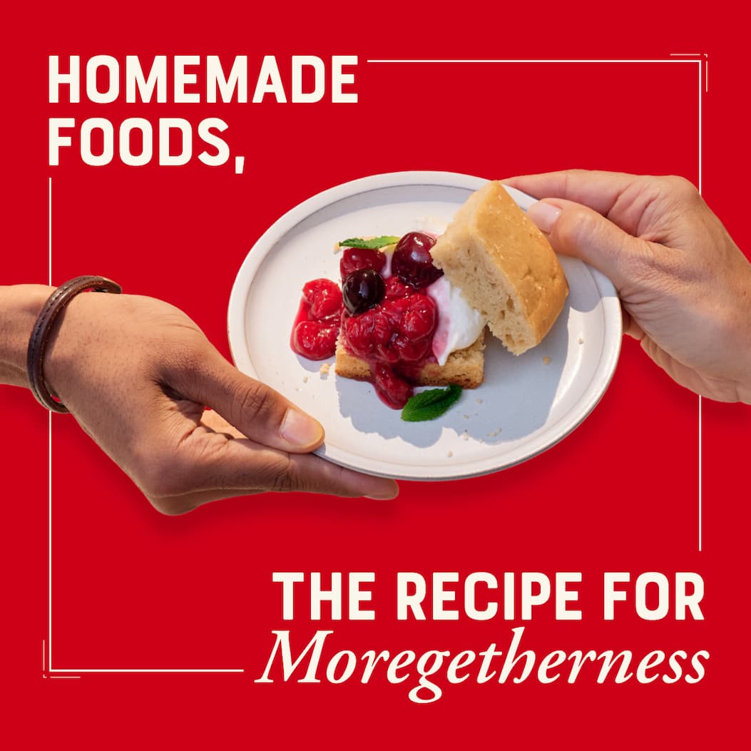 Homemade Foods, the recipe for Moregetherness. Image with red background, two hands passing a plate of sour cherry shortcake