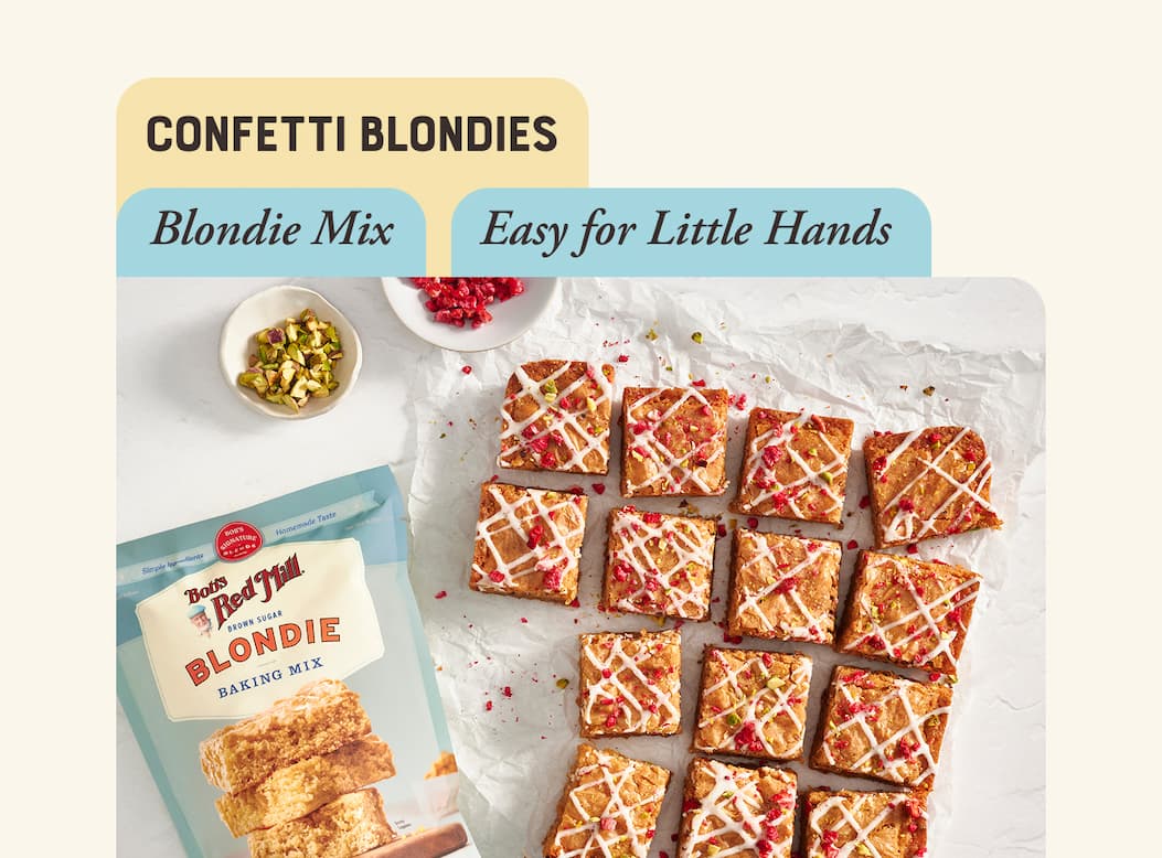 Confetti Blondies made with Blondie Mix. Image of blondies sliced into squares, topped with icing and freeze dried fruit
