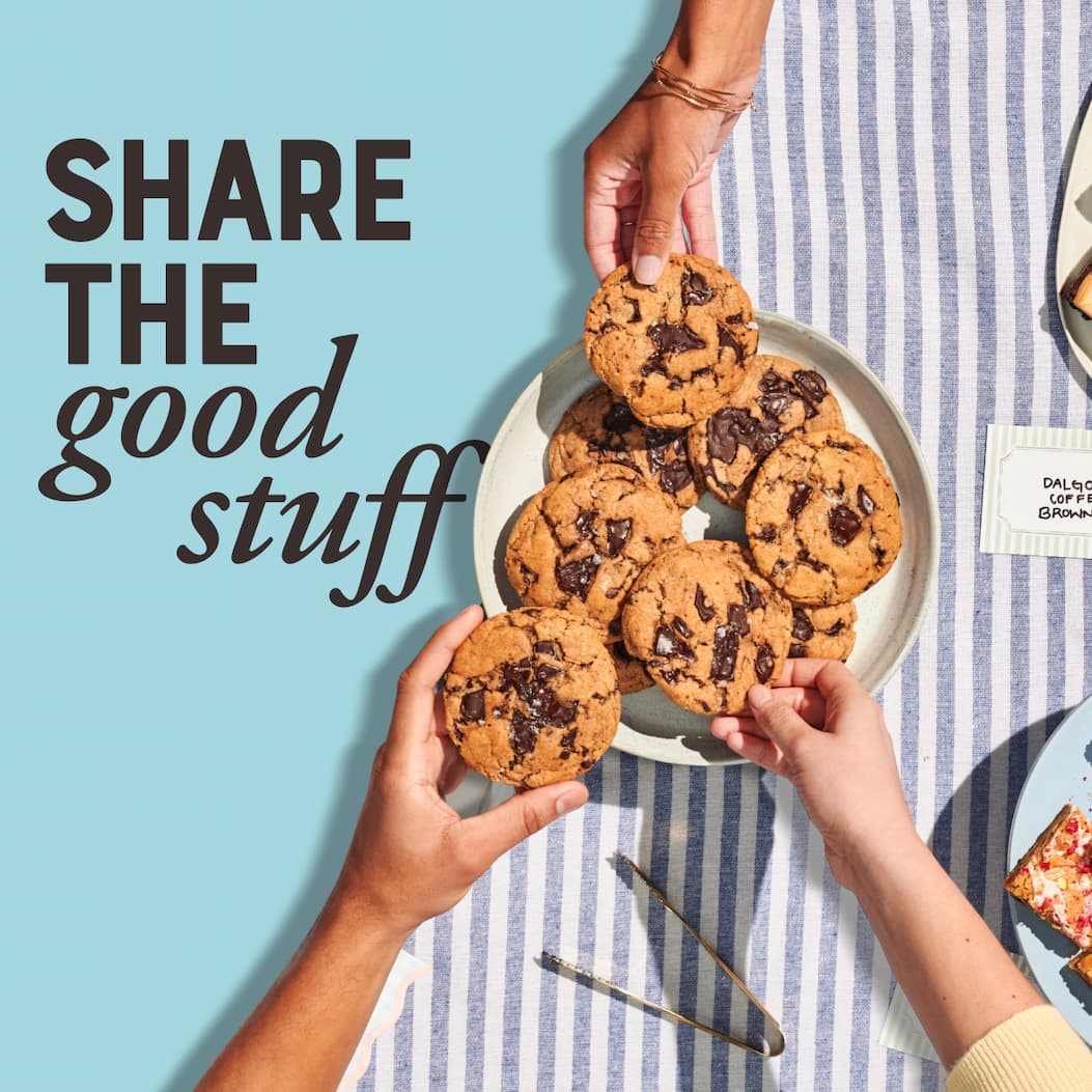 Share the good stuff. Image of Tahini Chocolate Chip Cookies on a plate with hands grabbing cookies.