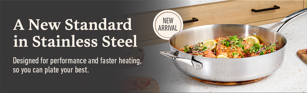 A new standard in stainless steel, new arrival badge, stainless steel pan with cooked food and fresh garnish on a kitchen counter