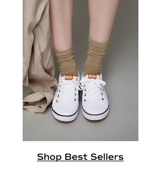 A pair of Center III Canvas Lace-Ups in white/blue shown on foot paired with beige socks. Shop Best Sellers.