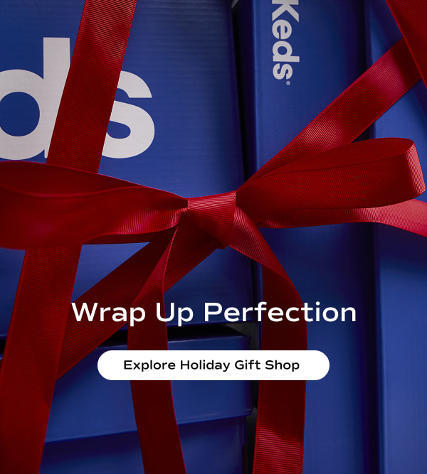 Close-up of Blue Keds shoeboxes tied with a red bow. The text says Wrap Up Perfection. Explore the Holiday Gift Shop.