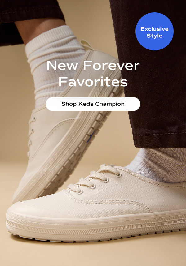 A woman with one foot up and one foot down wearing black jeans, ribbed socks, and the Keds Champion Toe Cap Coated Canvas in parchment. The email says New Forever Favorites. Shop Keds Champion.